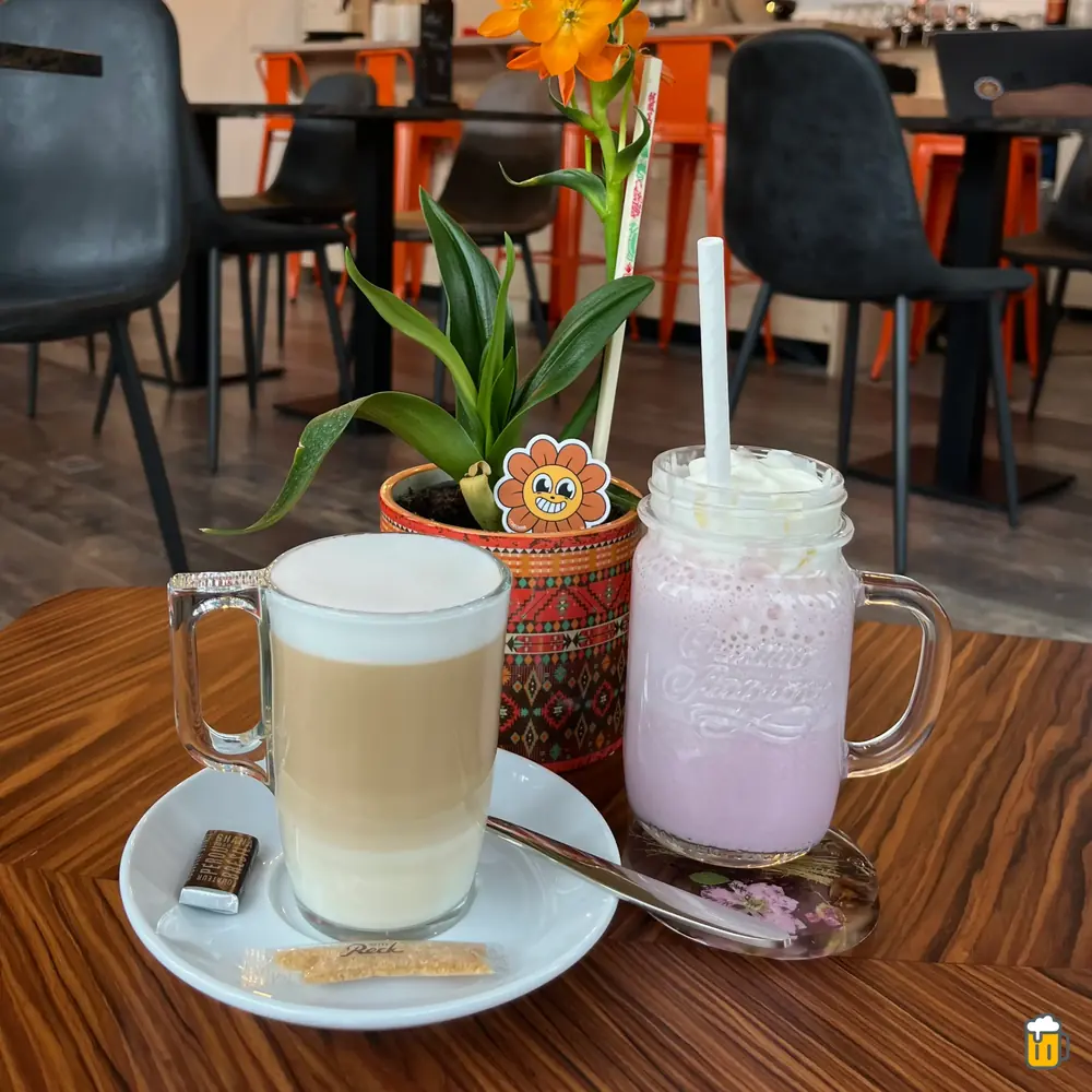 Latte et milkshake sur une table de la salle, chaises orange
