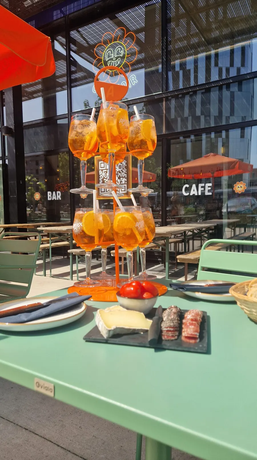 Arbre à spritz et planchette sur une table de la terrasse du Créchoir